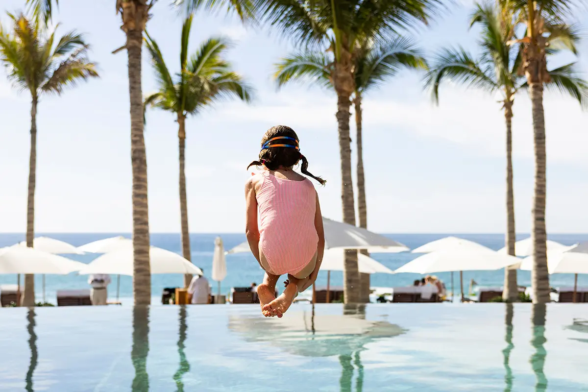 Young girl cannon balling into a pool at a hotel